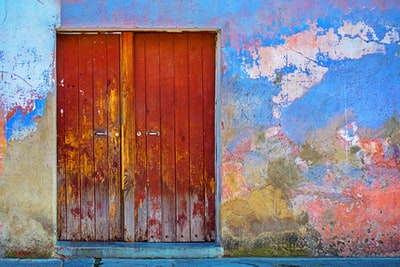 蓝色、红色和棕色漆墙的红色木门